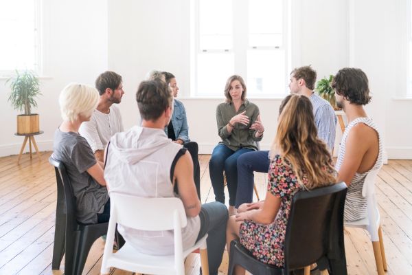 People taking part in a support group meeting in a bright, modern room.